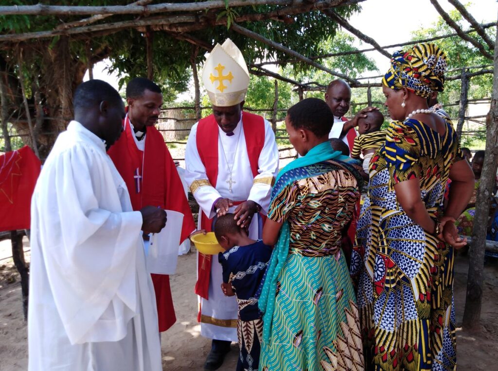 WCD-Bischof Isaac Kissiri Laiser tauft in einer dörflichen Astkirche ein Kind (Foto:Claus Heim)