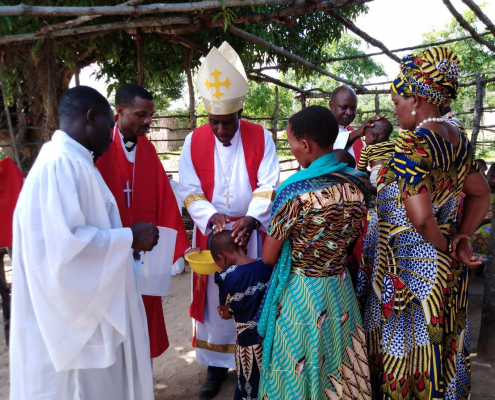 WCD-Bischof Isaac Kissiri Laiser tauft in einer dörflichen Astkirche ein Kind (Foto:Claus Heim)