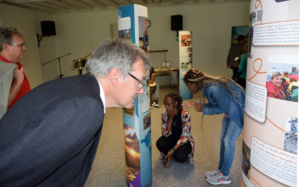 Die Ausstellung „Mission und Migration im 21. Jahrhundert“ stößt bei den Besucher*innen der Eröffnung auf intensives Interesse. Im Vordergrund Mission EineWelt-Direktor Hanns Hoerschelmann.