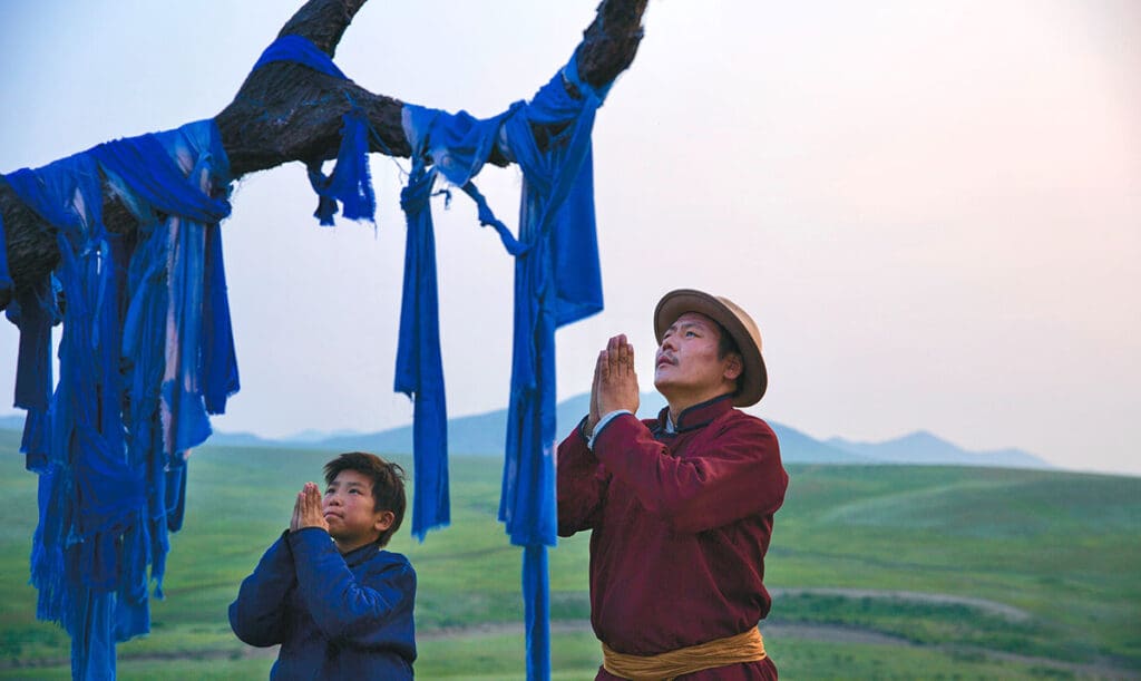 Amra (Bat-Ireedui Batmunkhw) und Erdene (Yalalt Namsrai) beten am Baum. (Foto: Pandora Film)